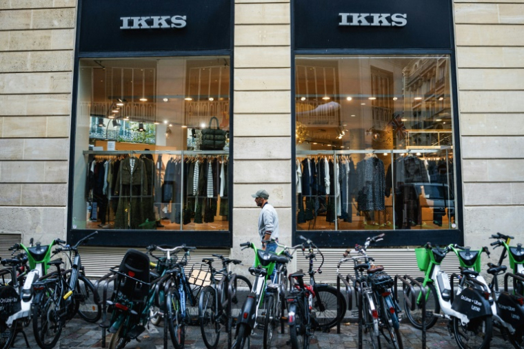 Un passant devant une boutique IKKS à Paris, le 3 octobre 2025 ( AFP / Dimitar DILKOFF )