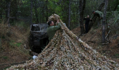 Des militaires ukrainiens installent un filet de camouflage sur un véhicule de combat dans la région de Zaporijjia le 24 octobre 2025 ( 65th Mechanized Brigade of Ukrainian Armed Forces / Handout )