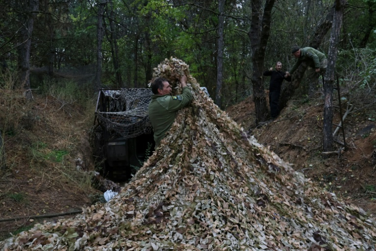 Des militaires ukrainiens installent un filet de camouflage sur un véhicule de combat dans la région de Zaporijjia le 24 octobre 2025 ( 65th Mechanized Brigade of Ukrainian Armed Forces / Handout )