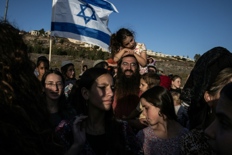 Des Israéliens sont venus fêter le retour de l'ex-otage à Gaza, Avinatan Or, dans la colonie Shiloh de Cisjordanie, le 21 octobre 2025. ( AFP / John Wessels )