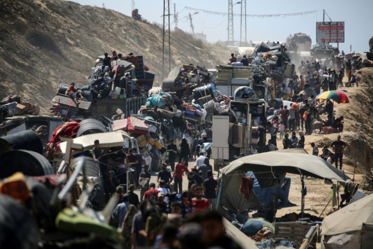 Des Palestiniens de la ville de Gaza se déplacent vers le sud de la bande de Gaza avec leurs affaires, sur la route côtière près du camp de réfugiés de Nousseirat dans le centre du territoire, pour fuir une opération militaire israélienne, le 19 septembre 2025 ( AFP / Eyad BABA )