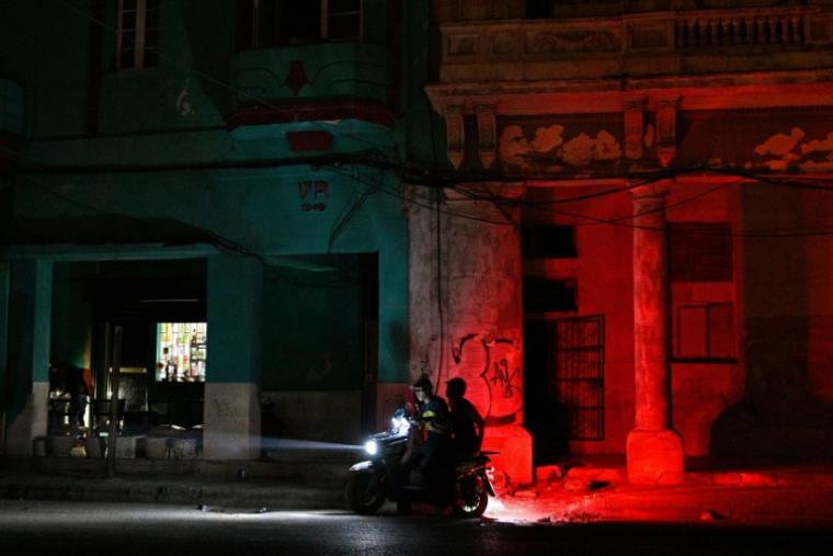 Un homme conduit une moto dans une rue pendant une panne de courant à La Havane, le 16 mars 2026 ( AFP / ADALBERTO ROQUE )