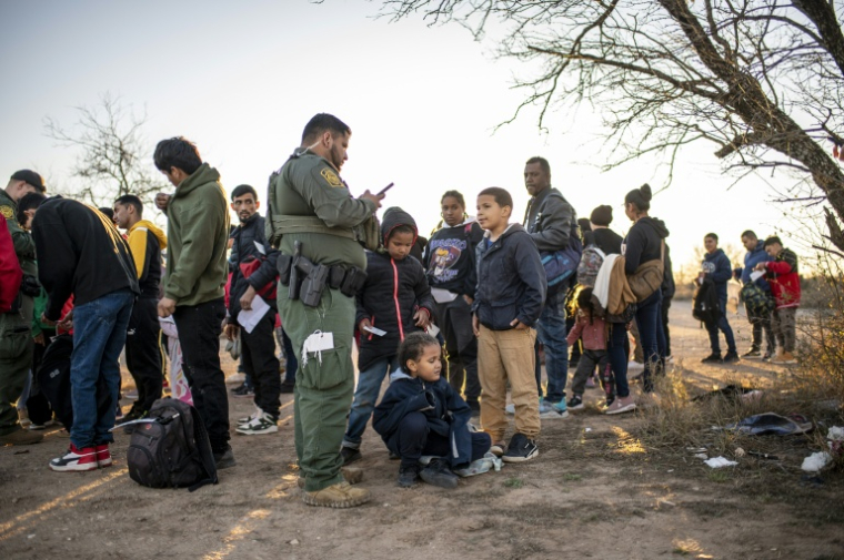Un groupe de migrants sont contrôlés par la police aux frontières près d'Eagle Pass, au Texas, le 4 février 2024 ( AFP / SERGIO FLORES )