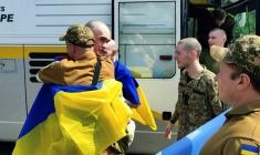 Photo prise et diffusée par le service de presse présidentiel ukrainien, le 9 juin 2025, de prisonniers de guerre ukrainiens enveloppés de drapeaux nationaux après un échange dans un lieu non divulgué  ( Service de presse de la présidence ukrainienne / Handout )