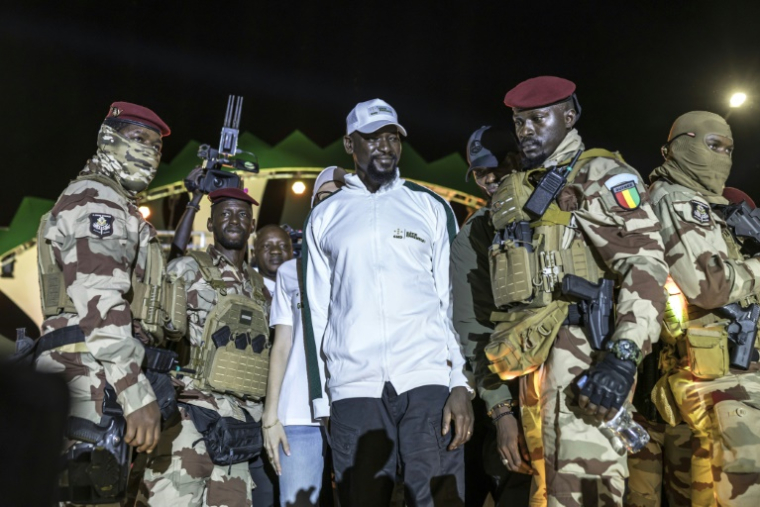 Le président guinéen et candidat à la présidence Mamadi Doumbouya (au centre) salue ses partisans lors de son dernier meeting électoral avant l'élection présidentielle, à Conakry, le 25 décembre 2025. ( AFP / PATRICK MEINHARDT )
