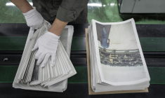 Un employé emballe l'œuvre du photographe Kazuma Obara, "The Newspaper", à Kumiyama, au Japon, le 19 mars 2026 ( AFP / Yuichi YAMAZAKI )