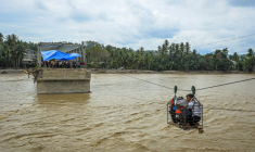 Des villageois utilisent une cabine sur câble pour traverser une rivière après la destruction d'un pont à Bireuen, en Indonésie, le 2 décembre 2025 ( AFP / AMANDA JUFRIAN )