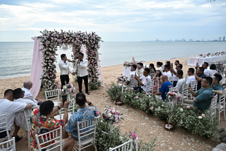 Les Chinois Song Jihan (g) et Wang Zengyi avec leurs nvités lors de leur cérémonie de mariage près de Pattaya, le 31 mai 2025 en Thaïlande ( AFP / Lillian SUWANRUMPHA )