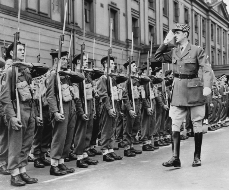 Le chef des Forces françaises libres (FFL), Charles de Gaulle, salue des marins alors qu'il passe en revue les troupes françaises lors du défilé militaire célébrant la fête nationale française à Londres, le 14 juillet 1942, durant la Seconde Guerre mondiale ( CENTRAL PRESS / - )