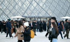 Des visiteurs devant la pyramide conçue par l'architecte sino-américain Ieoh Ming Pei et le musée du Louvre fermé lors d'une assemblée générale de ses personnels, appelés à la grève, le 15 décembre 2025 à Paris ( AFP / Blanca CRUZ )