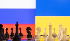 Des pièces de jeu d'échec devant les drapeaux de la Russie et de l'Ukraine