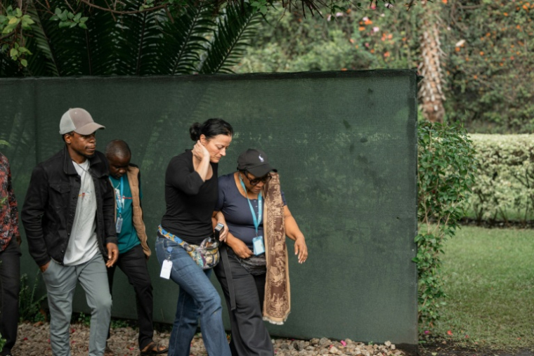 Des proches et collègues de Karine Buisset, employée de l'ONU tuée dans la nuit par une frappe de drone sur sa maison de Goma, dans l'est de la République démocratique du Congo (RDC), quittent les lieux le 11 mars 2026 ( AFP / Jospin Mwisha )