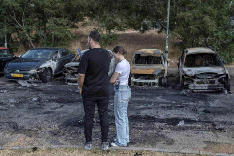Des habitants sur le site de l'explosion d'une voiture piégée à Holon, près de Tel-Aviv, le 28 juin 2026 ( AFP / ilia YEFIMOVICH )