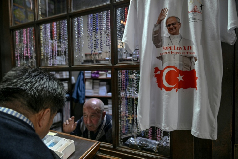 À Istanbul, le 24 novembre 2025, un t-shirt orné d'un portrait du pape Léon XIV et d'un drapeau turc est exposé devant la boutique de l'église Saint-Antoine-de-Padoue, à la veille de la visite du pape en Turquie. ( AFP / Ozan KOSE )