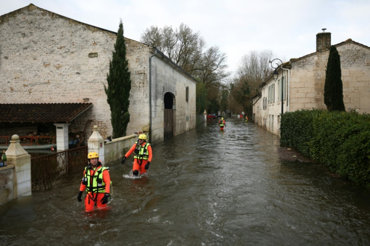 Des sauveteurs en mer dans une rue inondée lors d'une opération visant à évacuer des habitants isolés à Courcoury, en Charente-Maritime, le 21 février 2026 ( AFP / ROMAIN PERROCHEAU )