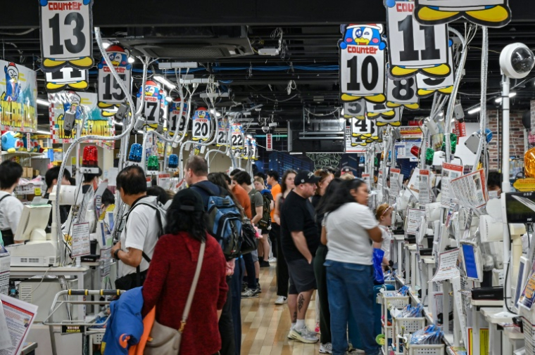 Des touristes aux caisses d'un magasin du détaillant discount japonais Don Quijote, dans le quartier de Shibuya à Tokyo, le 21 avril 2025 ( AFP / Richard A. Brooks )