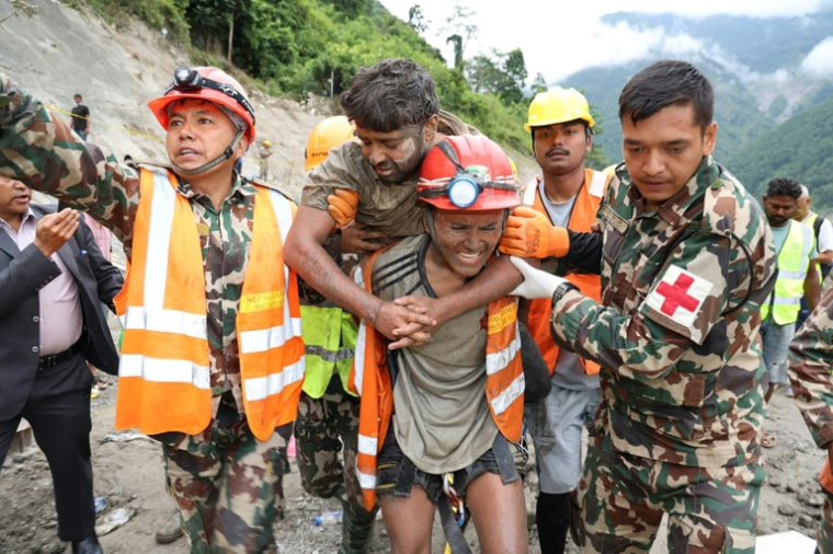 Photo fournie et diffusée par l'armée népalaise le 4 septembre 2026 montrant des militaires transportant un ouvrier resté coincé dans un tunnel, lors d'une opération de sauvetage sur le site du barrage en construction de Trishuli-3, dans le district de Rasuwa, au Népal ( NEPAL ARMY / Handout )