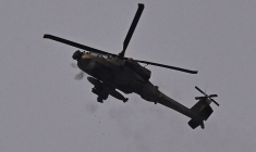 Un hélicoptère d'attaque AH-64 Apache de l'armée de l'air israélienne tire avec sa mitrailleuse, près de la frontière entre l'Israël et la bande de Gaza