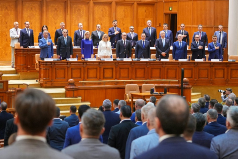 Le Premier ministre désigné Adrian Vestea (premier rang, g) et ses ministres écoutent l'hymne national roumain au Parlement avant un vote pour investir le nouveau gouvernement, le 22 juin 2026 à Bucarest, en Roumanie ( AFP / Mihai Barbu )