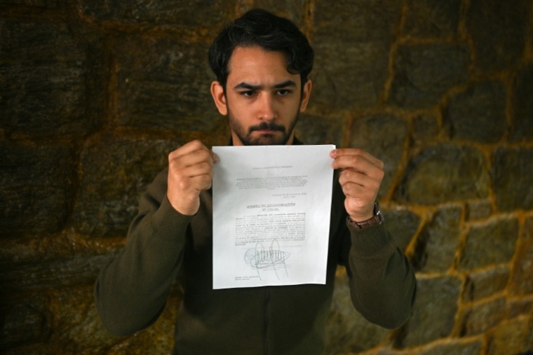 Ramon Guanipa, fils du dirigeant de l'opposition Juan Pablo Guanipa, montre un document de mise en liberté lors d'une conférence de presse après la nouvelle arrestation de son père à Caracas, le 9 février 2026 ( AFP / Federico PARRA )