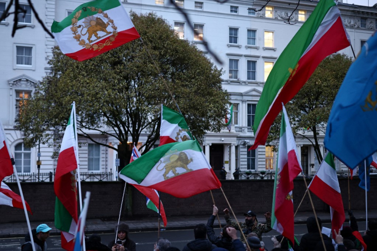Des manifestants brandissant le drapeau iranien d'avant-Révolution islamique, à Londres, le 9 janvier 2026 ( AFP / HENRY NICHOLLS )