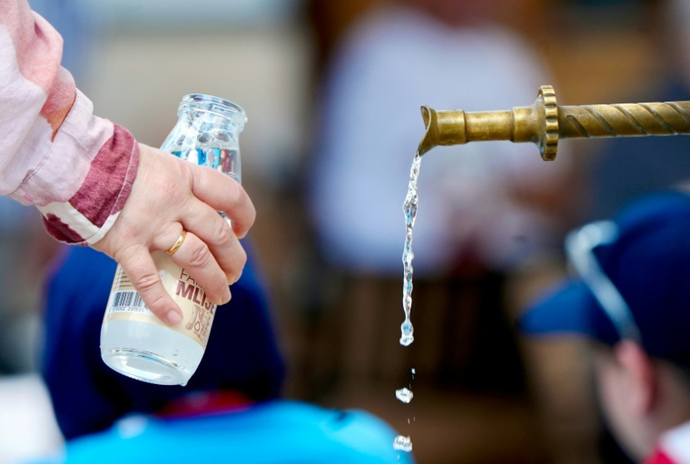 Une femme remplit une bouteille avec l'eau d'une fontaine dans le centre historique de Sarajevo pendant une vague de chaleur, le 26 juin 2026 en Bosnie ( AFP / ELVIS BARUKCIC )
