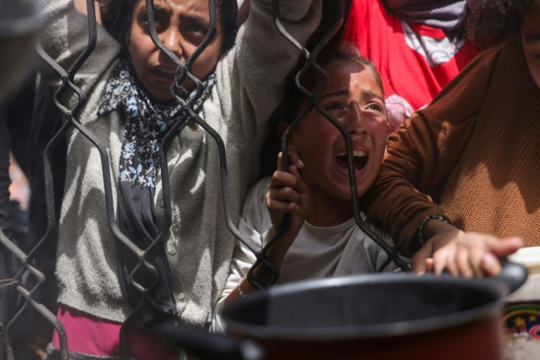 Des enfants palestiniens se bousculent pour obtenir un repas d'une cuisine caritative à Jabalia, dans le nord de la bande de Gaza, le 17 mai 2025 ( AFP / Bashar TALEB )