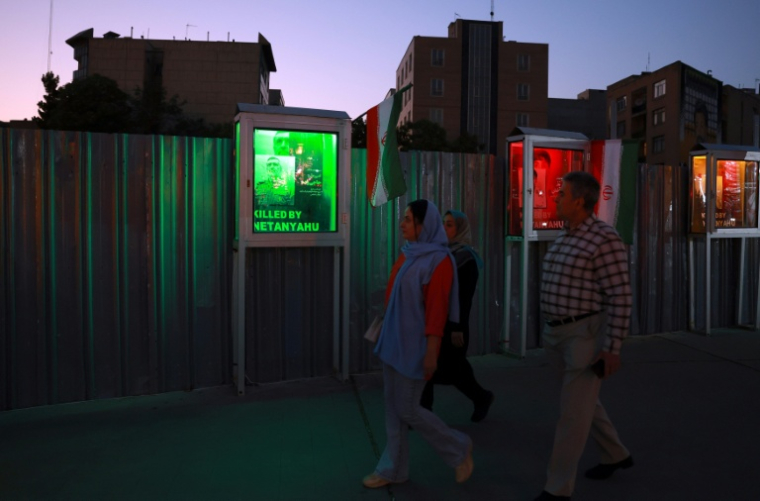 Des Iraniens passent devant le portrait d'un chef des Gardiens de la révolution tué par une frappe israélienne, à Téhéran le 23 juin 2025 ( AFP / - )