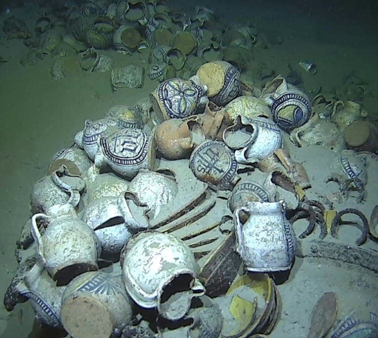 Photo diffusée par la Marine Nationale, le 11 juin 2025, d'une épave contenant des cruches globulaires à becs pincés, marquées du monogramme IHS du Christ ou de motifs végétaux ou géométriques gisant sur le sable au large de la côte, près de Ramatuelle, le 3 juin 2025 dans le Var ( Marine Nationale / Handout )