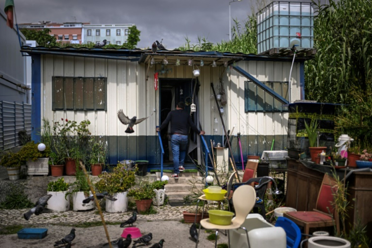 Carlos, jardinier municipal, entre dans le container où il vit depuis cinq ans, le 5 mai 2025 à Lisbonne, au Portugal ( AFP / PATRICIA DE MELO MOREIRA )