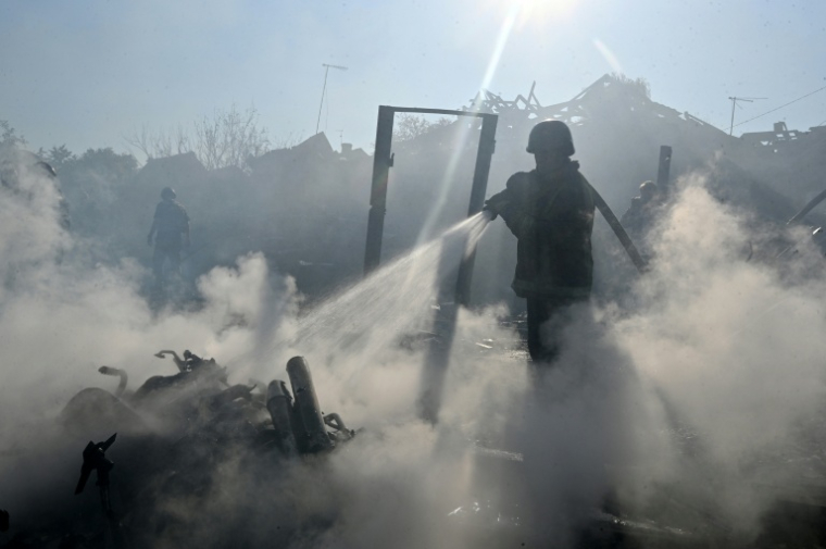 Un pompier éteint un incendie dans des maisons après une attaque russe meurtrière sur Kharkiv le 11 octobre 2026 ( AFP / SERGEY BOBOK )