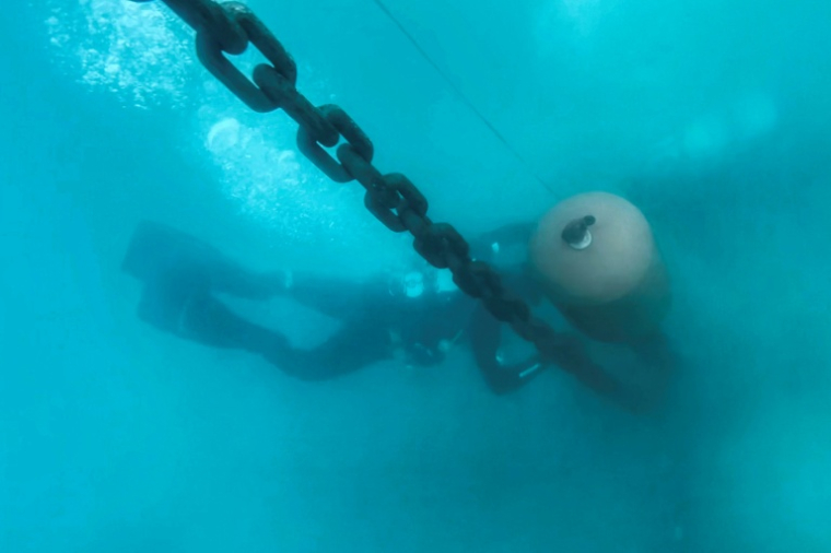 Des plongeurs professionnels installent un système d'amarrage écologique dans la baie de Porto Rafti, près d'Athènes, afin de protéger les herbiers de posidonie sensibles des fonds marins, le 11 février 2026 en Grèce ( AFP / Aris MESSINIS )