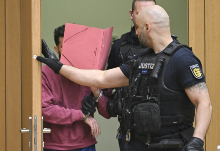 L'accusé (g) arrive dans la salle d'audience du tribunal régional de Stuttgart-Stammheim, dans le sud de l'Allemagne, le 13 février 2025 ( POOL / THOMAS KIENZLE )