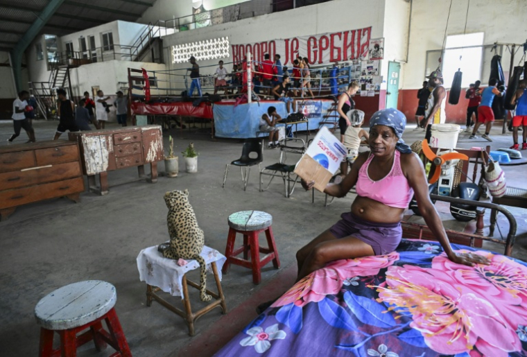 Felicia Crespo s'évente avec un morceau de carton dans son logement de fortune aménagé dans une salle de boxe où se sont installées des familles sans abri, dans la vieille Havane, le 9 juin 2026, à Cuba ( AFP / YAMIL LAGE )