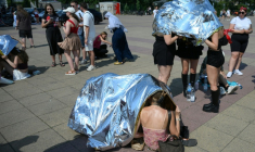 Des spectateurs se protègent de la chaleur avant un concert de Bruo Mars à l'Olympic stadium  de Berlin, le 28 juin 2026 ( AFP / RALF HIRSCHBERGER )