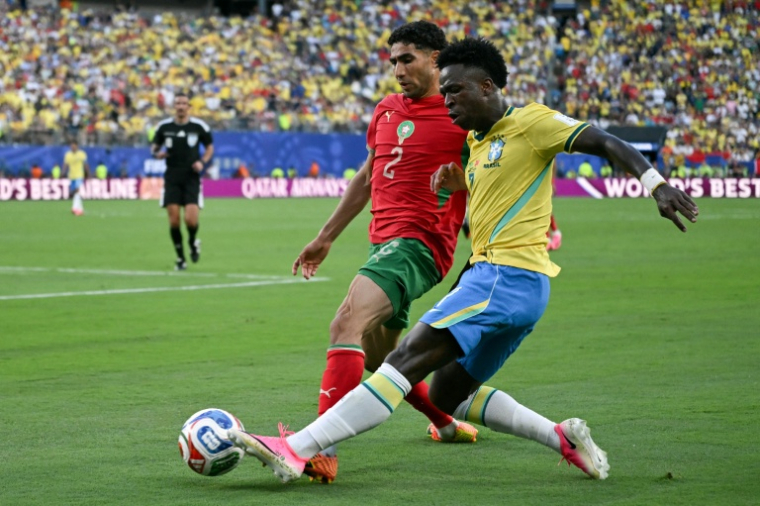 Achraf Hakimi (g) à la lutte avec Vinicius Junior lors du match du Groupe C du Mondial 2026 entre le Maroc et le Brésil (1-1), le 13 juin à East Rutherford. ( AFP / Mauro PIMENTEL )