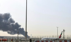 Un avion sur le tarmac de l'aéroport de Dubaï d'où s'élève la fumée d'un incendie, le 16 mars 2026 aux Emirats arabes unis ( AFP / - )