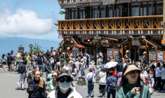 Des touristes devant le restaurant et la zone commerçante de la 5e station de la ligne Fuji Subaru. Cet endroit mène au sentier Yoshida populaire pour les randonneurs gravissant le mont Fuji, avant sa réouverture pour la saison à Narusawa (préfecture de Yamanashi), le 19 juin 2024. ( AFP / PHILIP FONG )
