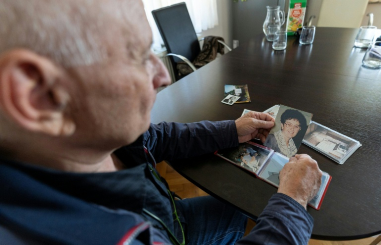 Juraj Pievac regarde des photos de sa femme tuée par l'explosion d'une mine, le 24 mars 2026 dans le village de Brodani, près de Karlovac, en Croatie ( AFP / MARKO PERKOV )