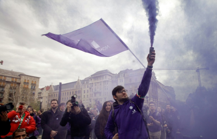 Des manifestants utilisent des fumigènes devant le Parlement, le 14 avril 2025 à Budapest ( AFP / Peter Kohalmi )