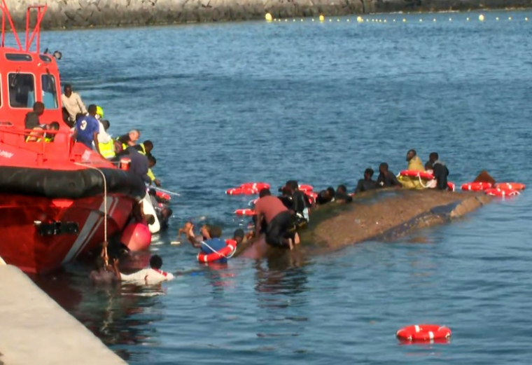 Image tirée d'une vidéo diffusée par Television Canaria montrant des sauveteurs tentant de sauver des migrants de la noyade après le chavirement de leur bateau surchargé, dans le port de La Restinga, sur l'île d'El Hierro, le 28 mai 2025 aux Canaries ( TELEVISION CANARIA / Handout )