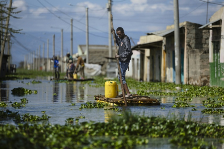 Des habitants se déplacent le 17 novembre 2025 à l'aide de radeaux de fortune dans une rue de ce qui fut leur quartier des rives du lac Naivasha, dans le centre du Kenya, inondé par la montée des eaux ( AFP / Tony KARUMBA )