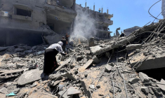 Palestinians search for casualties at the site of Israeli strikes on houses