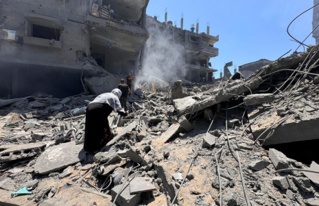 Palestinians search for casualties at the site of Israeli strikes on houses