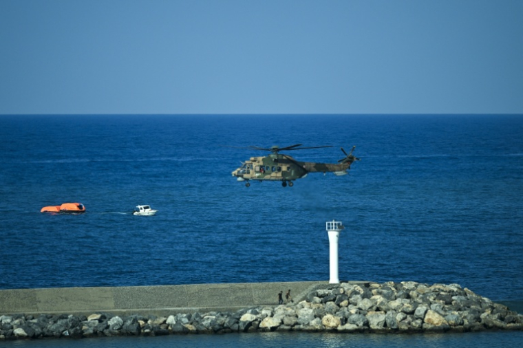 Un hélicoptère turc survole les eaux lors d'une opération de sauvetage au large de Kyrenia, dans la République turque de Chypre du Nord — entité autoproclamée reconnue uniquement par la Turquie — le 30 août 2026, après le chavirage d'un ferry ( AFP / Jewel SAMAD )