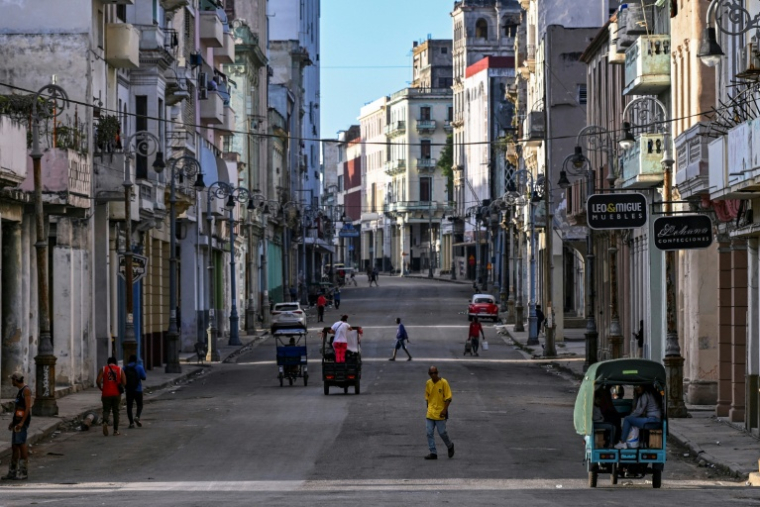 Des habitants dans une rue de La Havane privée d'électricité lors d'une panne de courant nationale à Cuba, le 22 mars 2026 ( AFP / YAMIL LAGE )