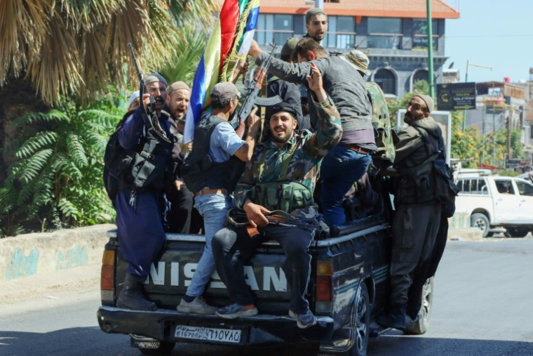 Des combattants druzes syriens parcourent les rues de la ville de Soueida, au sud du pays, après le retrait des troupes gouvernementales, le 17 juillet 2025 ( AFP / Shadi AL-DUBAISI )