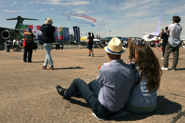 Des visiteurs regardent des avions de la patrouille de France pendant la 55e édition du Salon international de l'aéronautique et de l'espace à l'aéroport du Bourget, au nord de Paris, le 20 juin 2025 ( AFP / Thomas SAMSON )