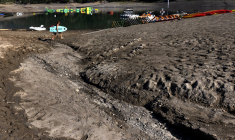 Le lac de Serre-Ponçon, dans les Alpes, à une cinquantaine de kilomètres de la station du Grand Puy, le 25 août 2022. This view taken on August 25, 2022, shows a man carrying a water ski-ing board on the Serre-Ponçon lake at Ubaye Serre-Ponçon in The French Alps, as water levels decreased 16 meters due to the drought. The latest monthly analysis by the European Union's Global Drought Observatory (GDO) highlighted the risk of ongoing soil dryness caused by successive heatwaves and a persistent lack of rainfall as it maintained its warning issued with the previous report that nearly half of the EU's territory is at risk of drought. (Photo by JOEL SAGET / AFP) ( AFP / JOEL SAGET )