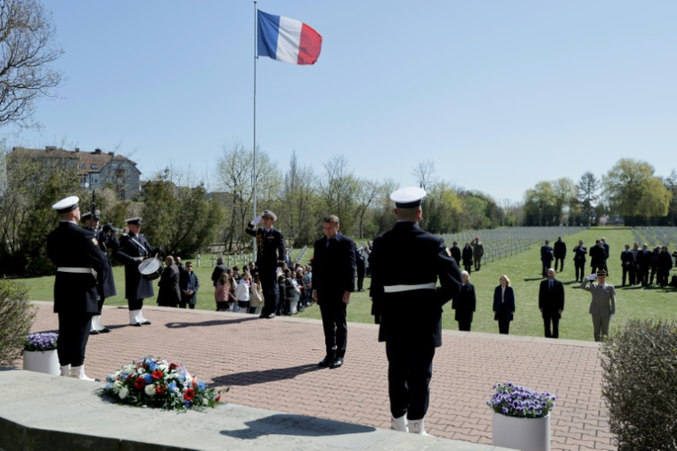 Le président français Emmanuel Macron (c) dépose une gerbe de leurs au cimetière militaire français de Gdansk, lors d'une visite en Pologne, le 20 avril 2026 ( AFP / Ludovic MARIN )
